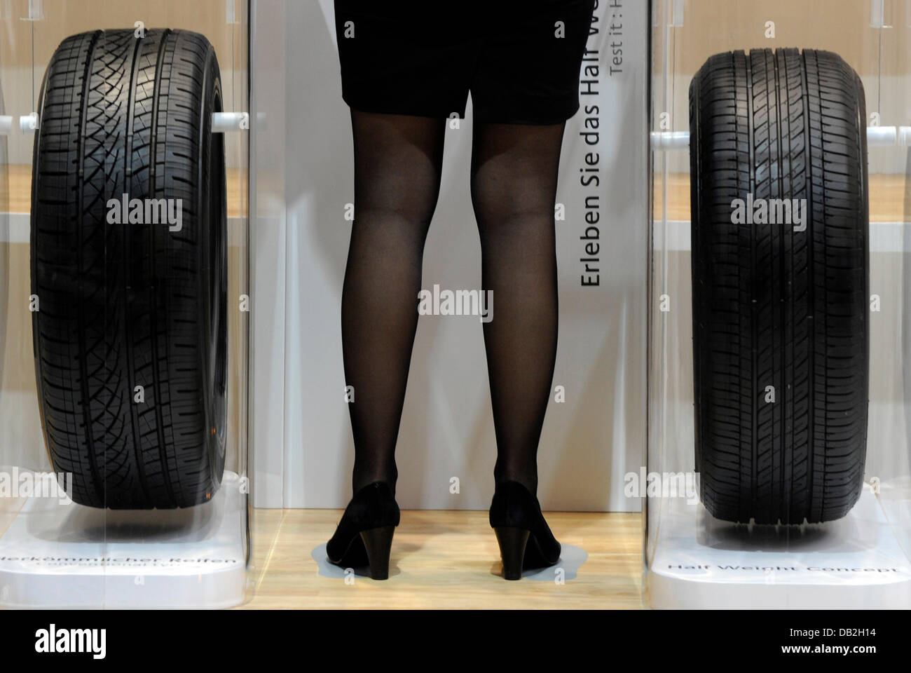 Une hôtesse se tient entre deux pneus à l'International de l'IAA de Francfort, Allemagne, 12 septembre 2011. Du 15 au 25 septembre 2011 exposants du monde entier présenteront les nouvelles tendances de l'industrie automobile, dirigé par mobilité électronique et des véhicules hybrides. Photo : Boris Roessler Banque D'Images