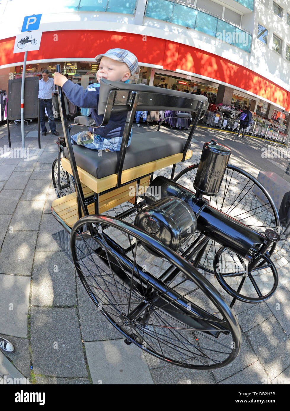 David est assis sur une réplique d'une Benz Patent-Motorwagen n° 1 dans la région de Mühlburg de Karlsruhe, Allemagne, 12 septembre 2011. La copie a été mis en place pour se souvenir de la voiture pioneer Carl Benz avec une place de parking. L'œuvre, qui pèse environ 500 kilogrammes, est dotée de sièges en cuir avec dos comme sur l'original. Le travail va y rester pour toujours, où la longue démoli birt Banque D'Images