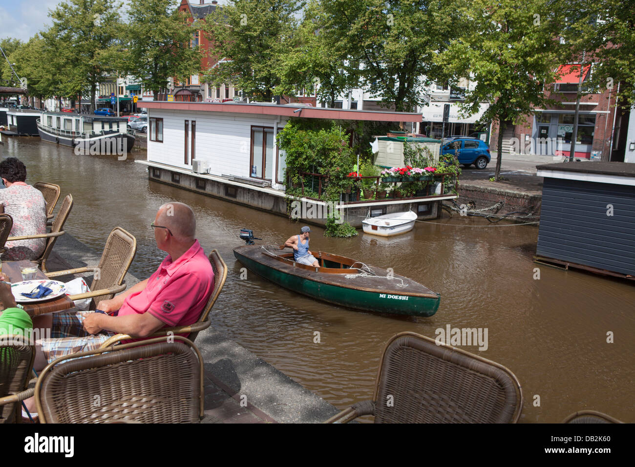 Bateau à voile à travers un canal avec des péniches dans le centre-ville de Groningue aux Pays-Bas Banque D'Images