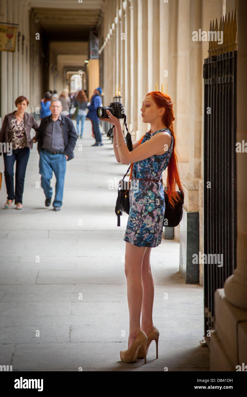 Grand modèle rousse en talons hauts en utilisant un dlsr, prendre des photos au palais royal, paris france Banque D'Images