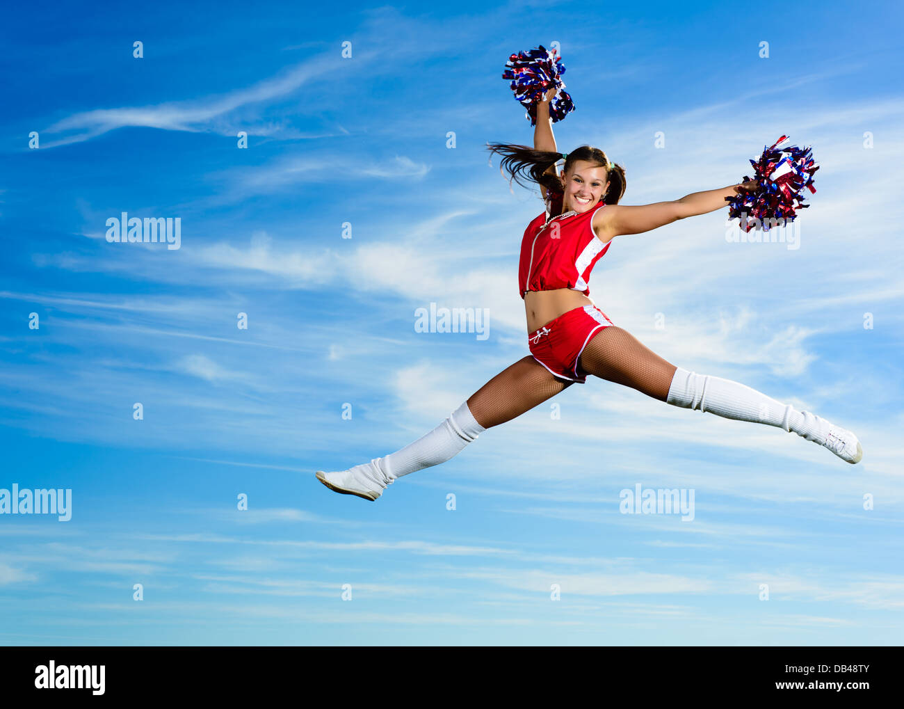 Les jeunes en cheerleader costume rouge jumping Banque D'Images