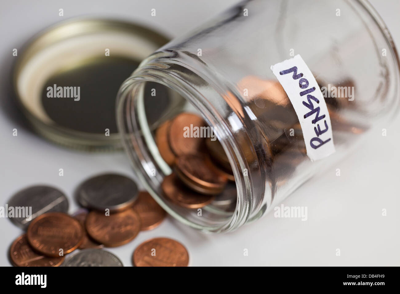 Pot en verre renversé de pièces enregistrées pour pension - USA Banque D'Images