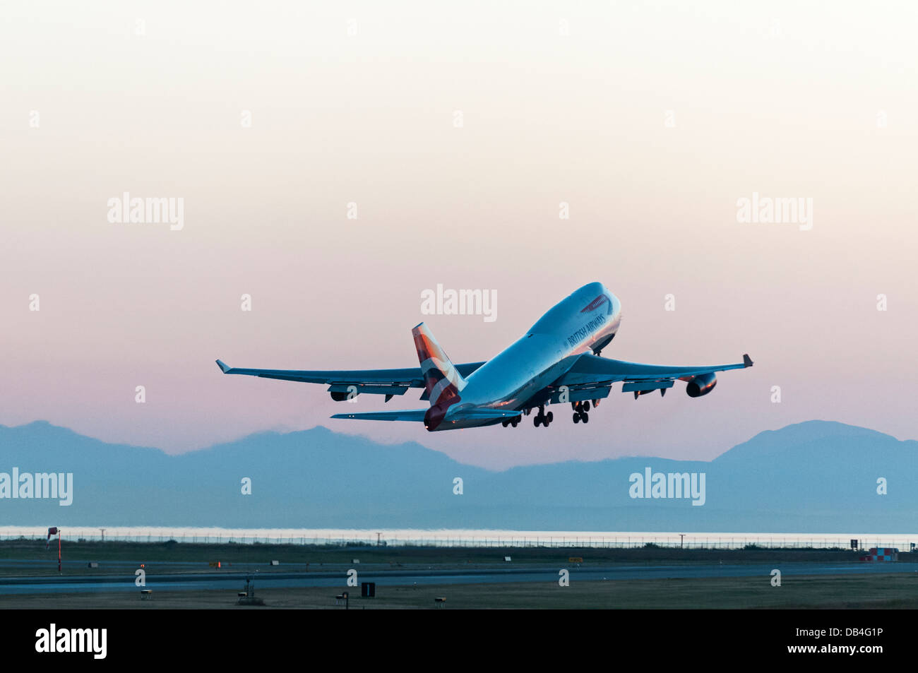 Un British Airways (BA) Boeing 747-400 (747-436) wide body jumbo jet airliner prend son envol au crépuscule, International de Vancouver YVR Banque D'Images