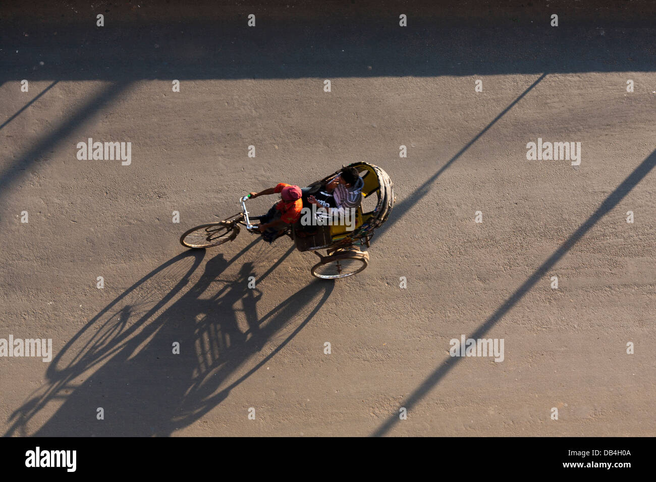 Vue de dessus de pousse-pousse casting shadows sur la route comme ils transport des passagers le long des rues de Chittagong au Bangladesh Banque D'Images