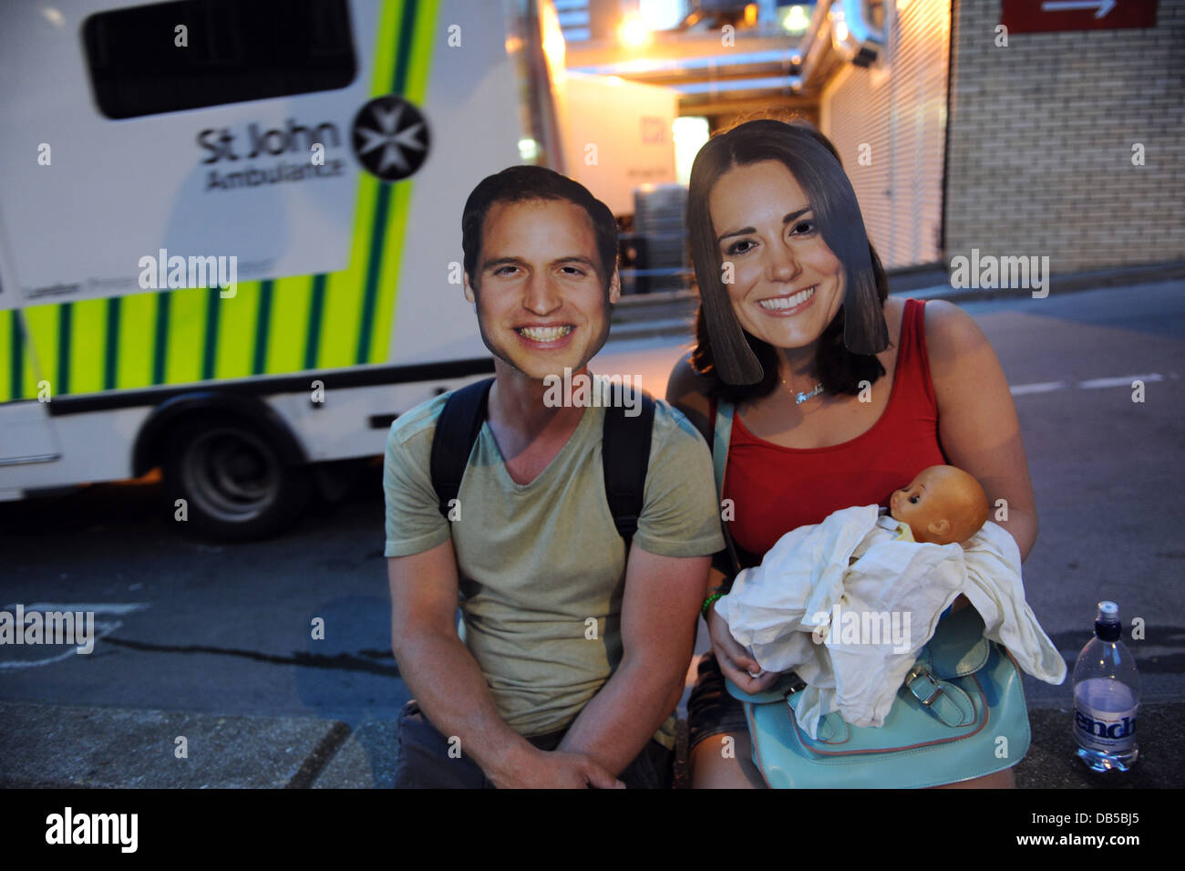 Deux touristes portant des masques du Prince William et la Princesse Kate dans l'attente de nouvelles de la Royal baby en dehors de l'hôpital St Marys Banque D'Images