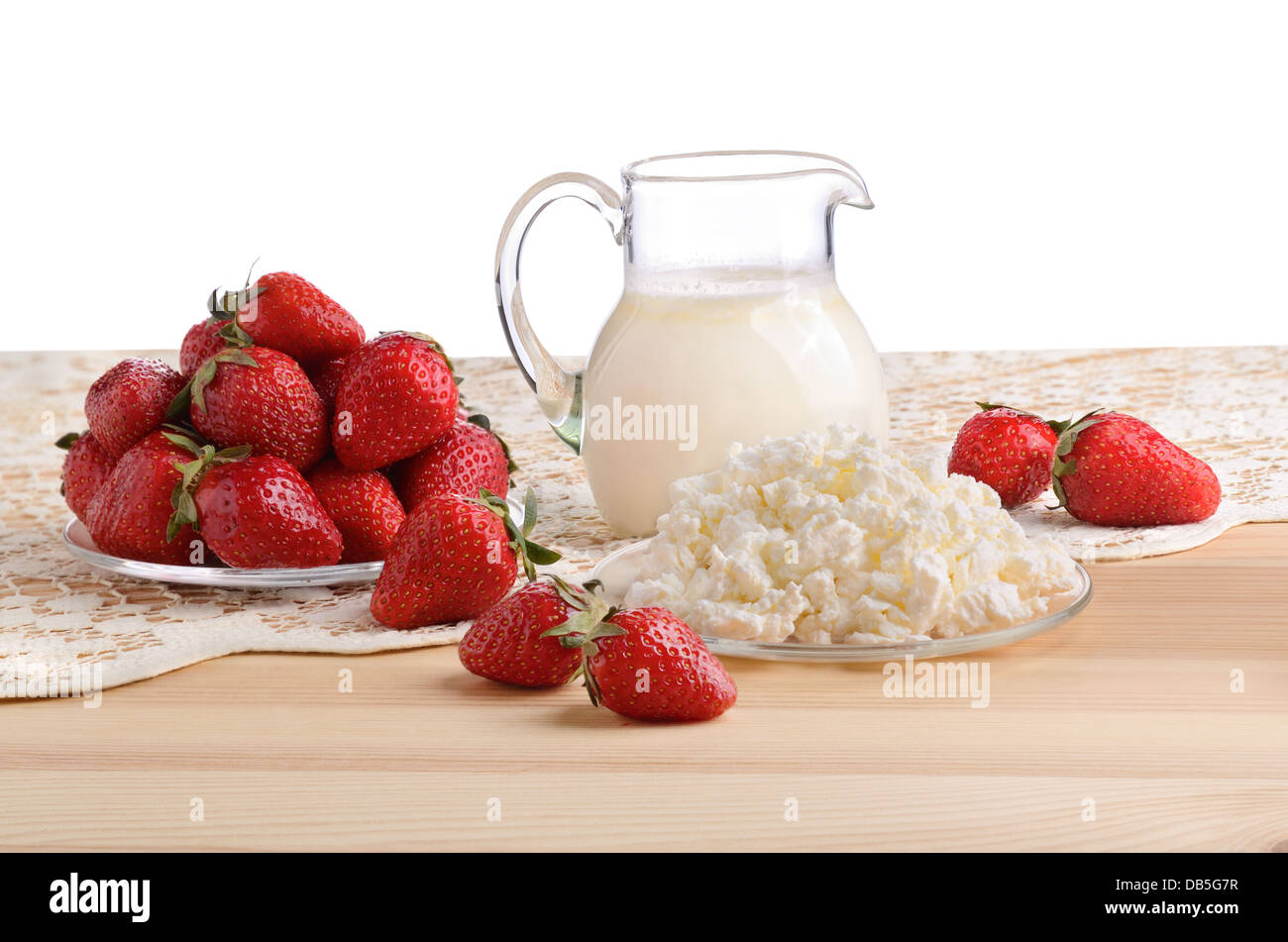 Une fraise mûre, du lait et du fromage cottage sur une nappe en bonneterie Banque D'Images