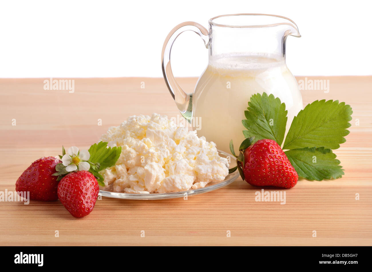 Une fraise mûre, du lait et du fromage cottage sur table en bois Banque D'Images