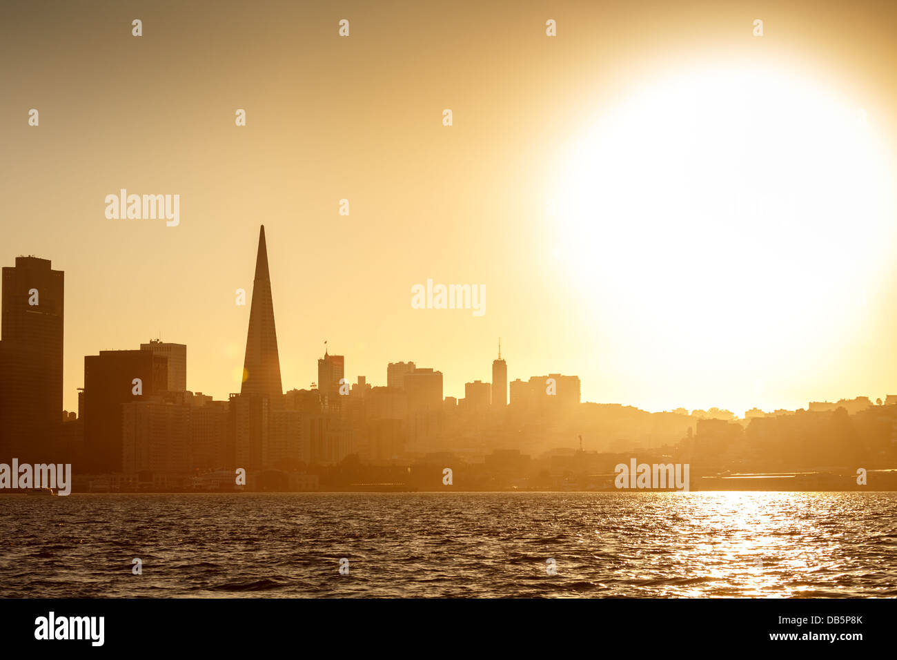 Grand, lumineux blanc soleil brille sur San Francisco silhouetting l'horizon au coucher du soleil. Banque D'Images