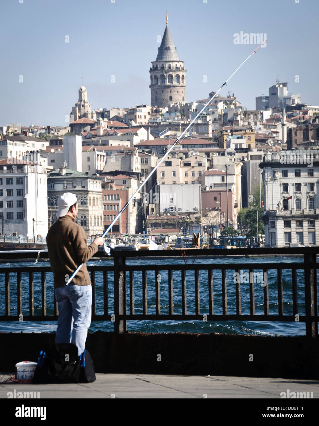 Istanbul, Turquie. L'homme sur le pont de pêche d'Ataturk, la Tour de Galata en arrière-plan. Banque D'Images