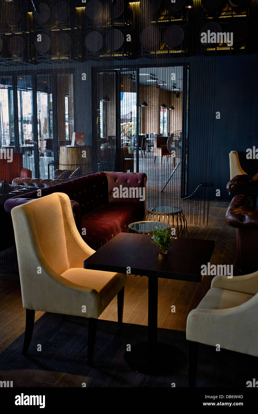 Intérieur moderne du restaurant. Coin salon avec ameublement doux et éclairage doux créant une atmosphère intime. Banque D'Images