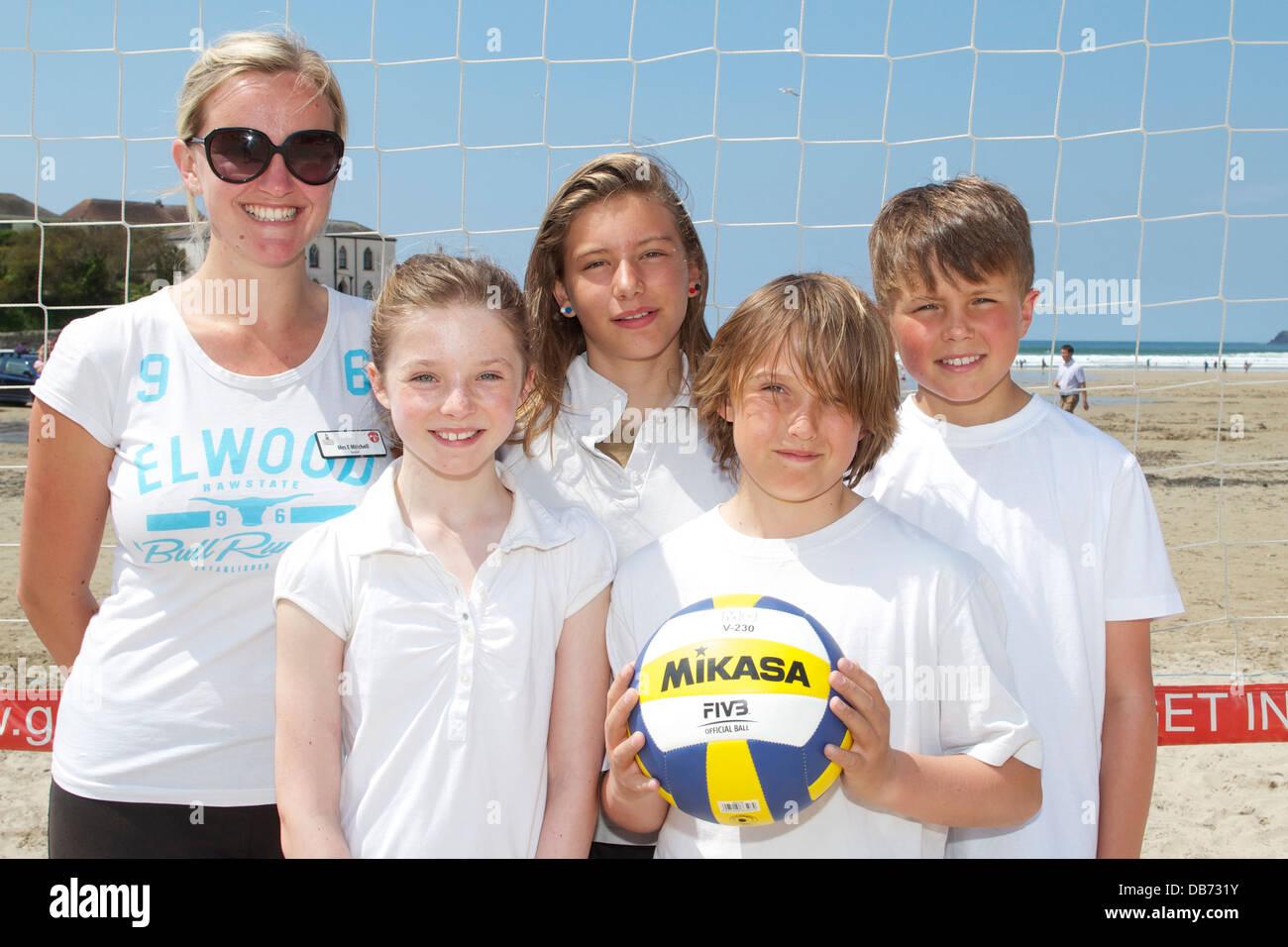 Sur la plage de Polzeath au soleil St Merryn jeunes Keeley, Erin, Josh, Toby et Coach Mme Mitchell attendent avec impatience le jeu d'allumette Banque D'Images