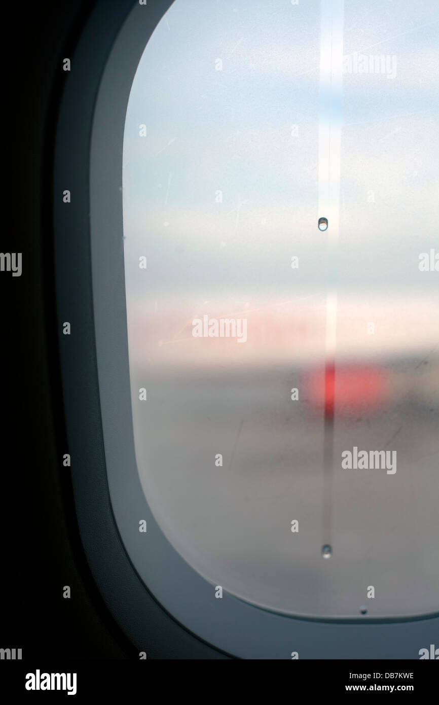 Les gouttes de pluie couler le long de la fenêtre d'un avion Banque D'Images