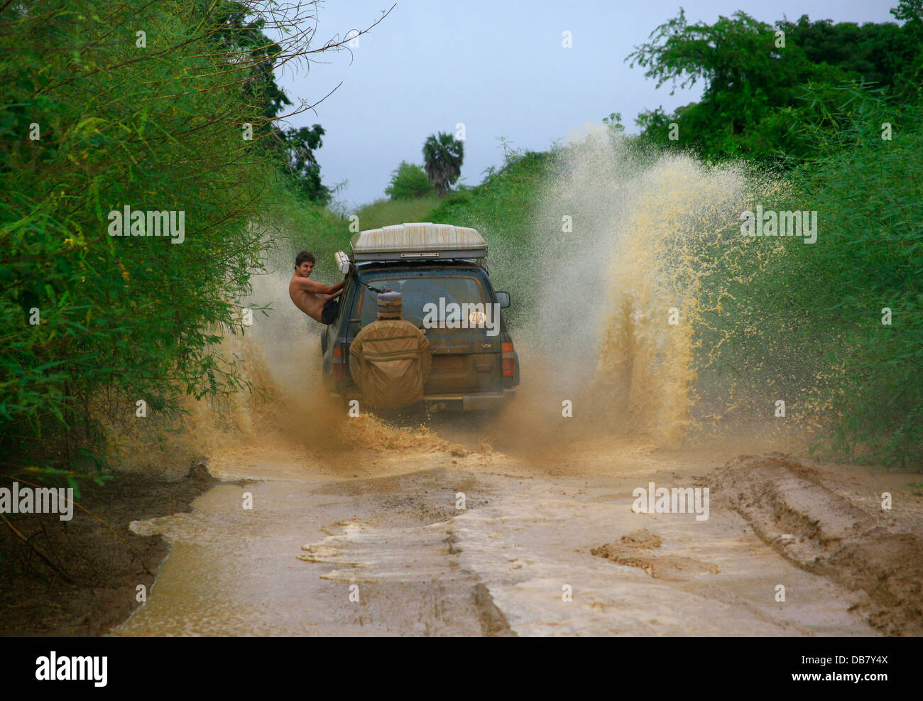 Loisirs - 4x4 offroad conduite driving adventure 4x4 à travers les lecteurs de flaque de boue water man hanging out car dare-devil fun Banque D'Images