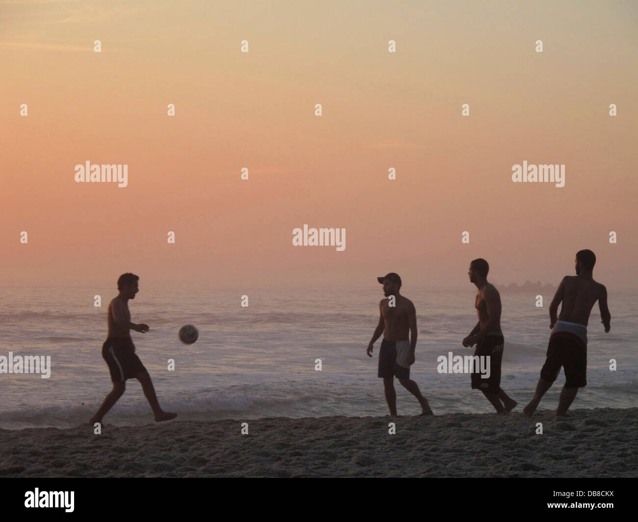 Les joueurs de football, de soccer au coucher du soleil sur la plage de Clifton, Cape Town, Afrique du Sud. Banque D'Images