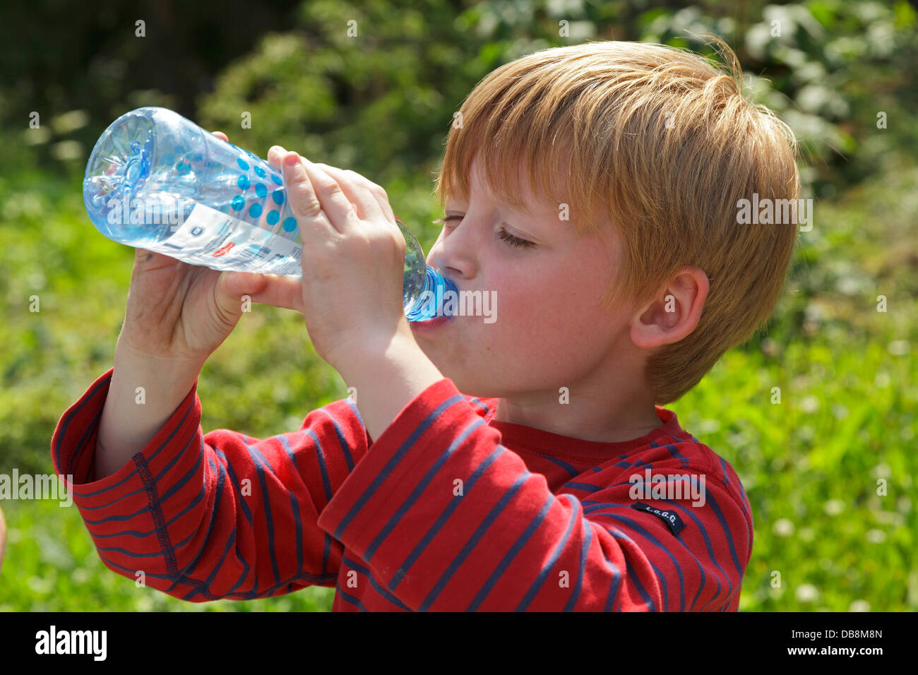 Jeune garçon d'une bouteille d'eau potable Banque D'Images