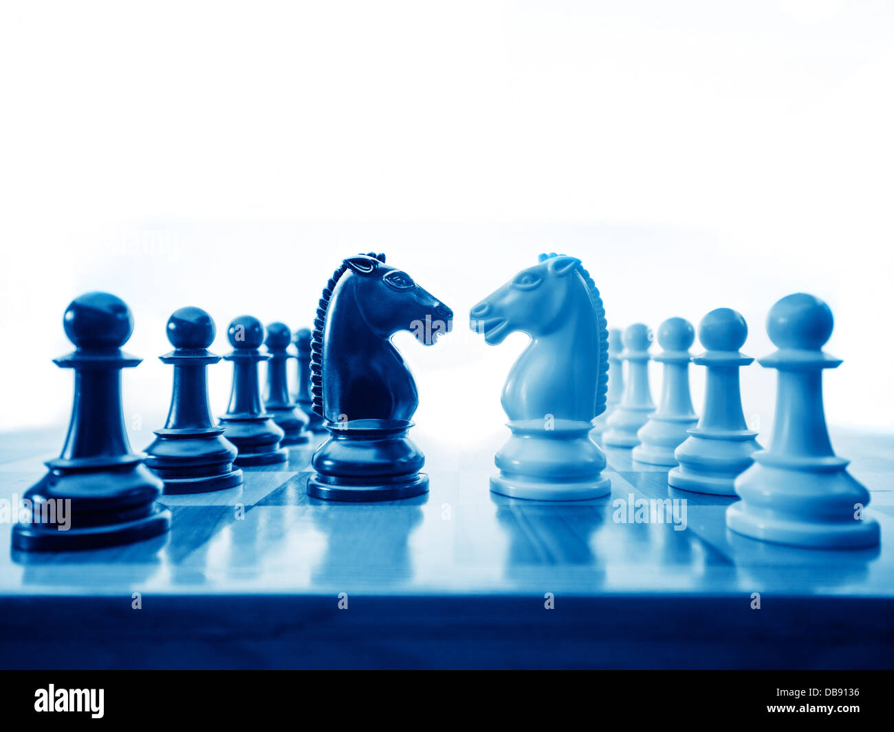 Pièces des échecs face au large sur l'échiquier, comme une métaphore de la guerre et des affaires Banque D'Images