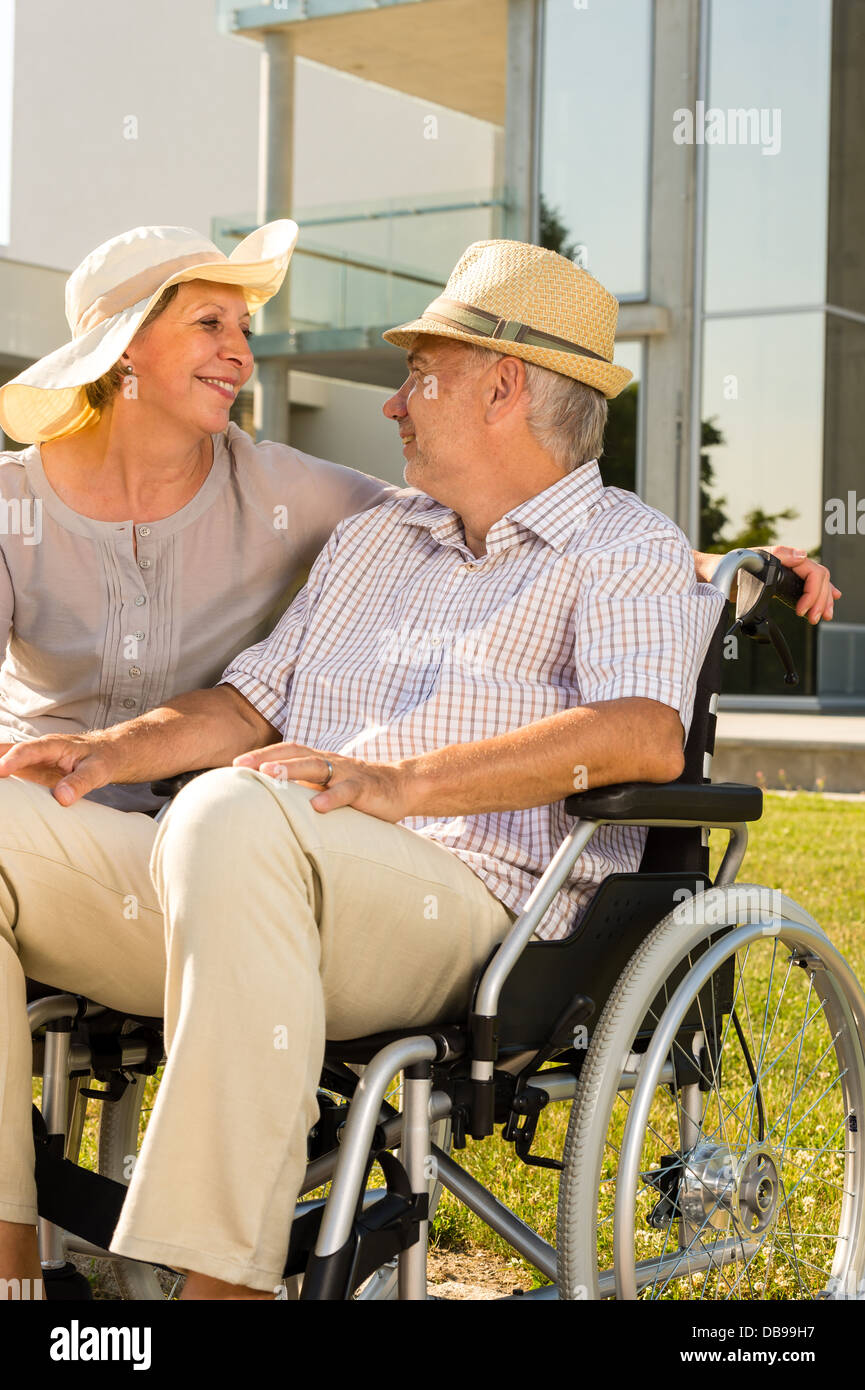 Mobilité retraite homme avec femme assis à l'extérieur Banque D'Images