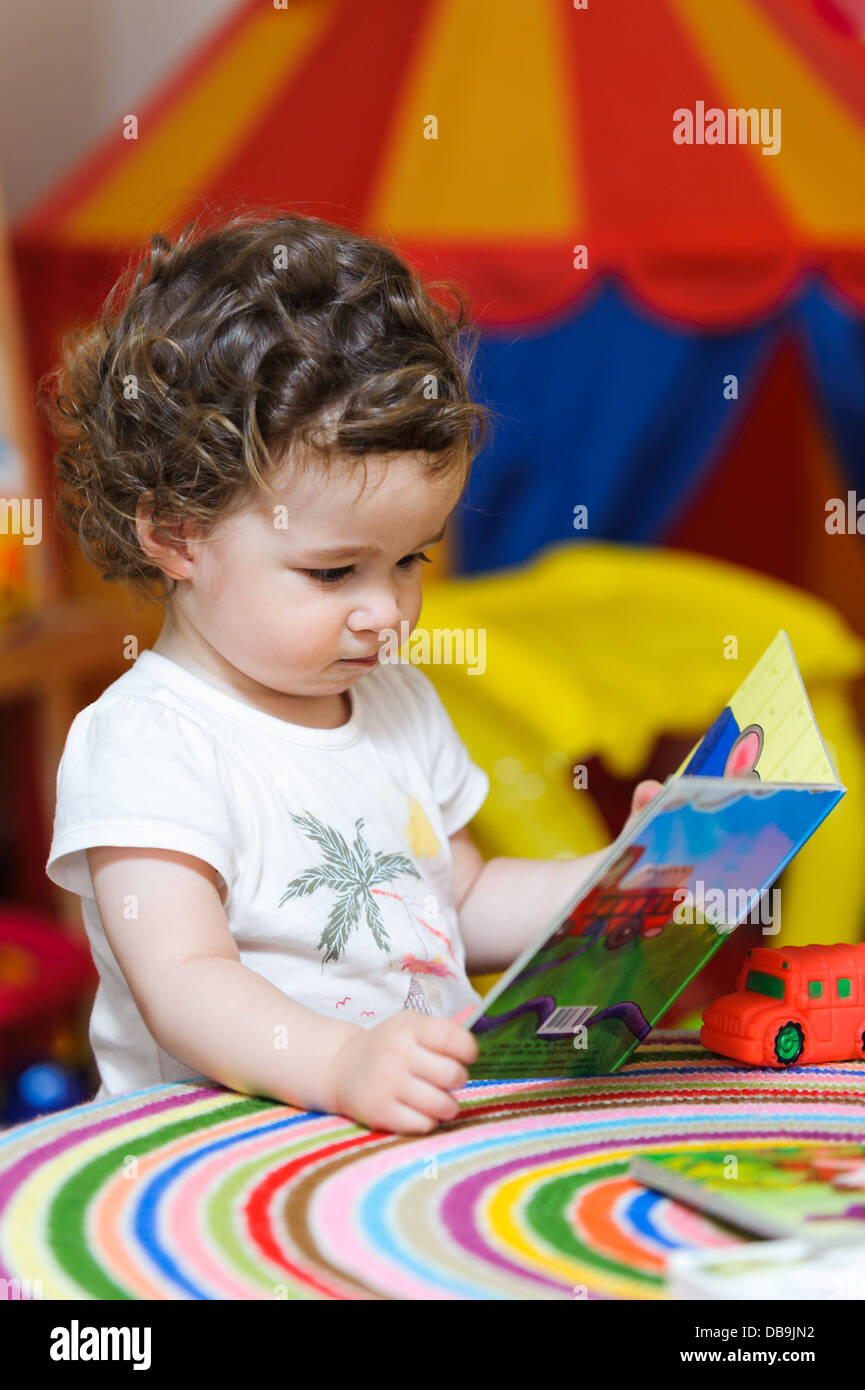 Petite fille d'âge préscolaire à un livre d'images Banque D'Images