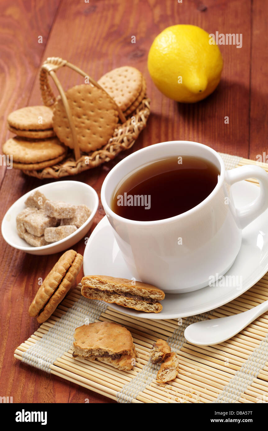 Tasse de thé et biscuits doux sur une table en bois Banque D'Images