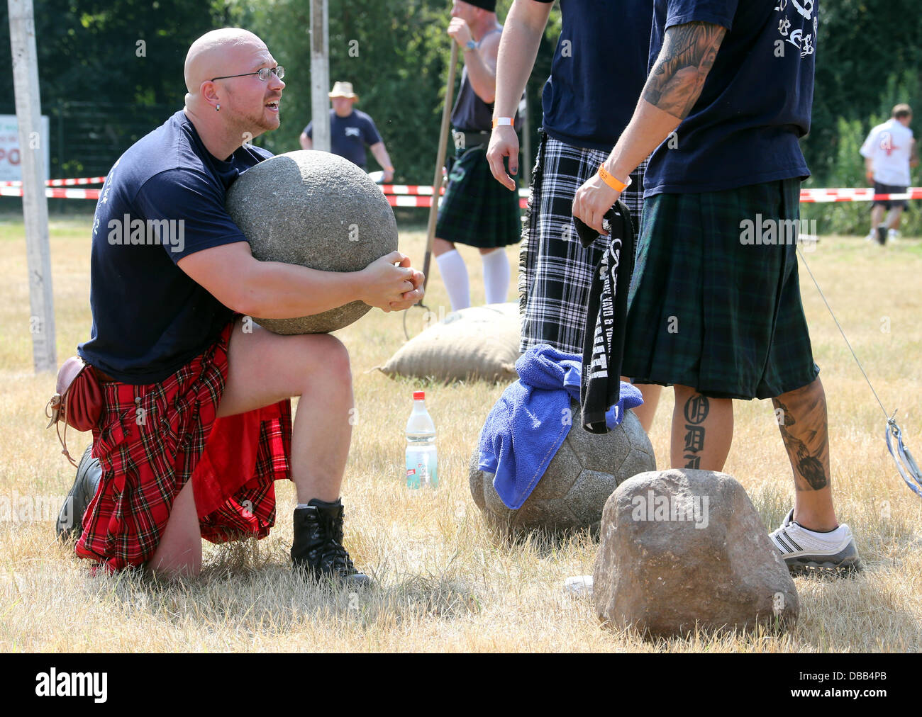 Berlin, Allemagne. 27 juillet, 2013. Un homme fort ascenseurs une porte une boule en pierre au cours de la Highland Games à Berlin le Gaerten der Welt à Berlin, Allemagne, 27 juillet 2013. Photo : WOLFGANG KUMM/dpa/Alamy Live News Banque D'Images