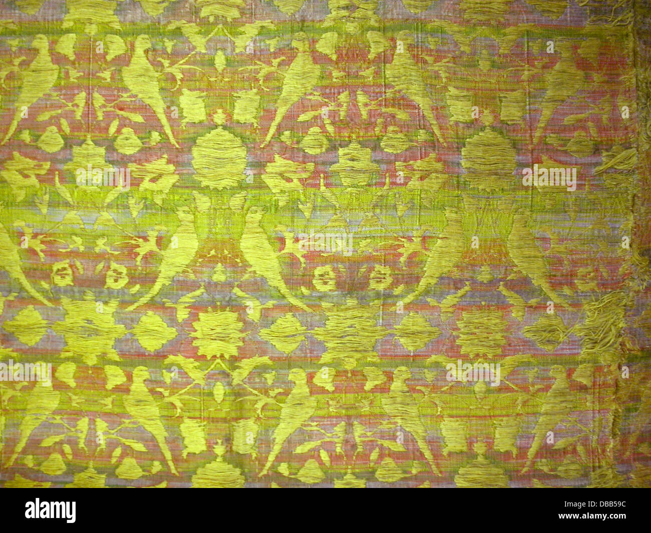 Ce textile présente un design complexe d'oiseaux et de fleurs, mettant en valeur l'artisanat qualifié dans la broderie. Le tissu est fabriqué à partir de coton avec bordure en dentelle de canette, soulignant les techniques artistiques de l'époque. Banque D'Images