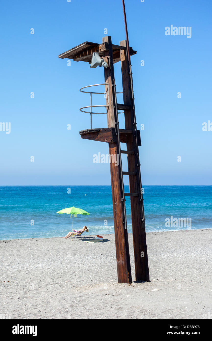 Lifeguard vide station sur une plage espagnole public avec juste une personne de soleil Banque D'Images