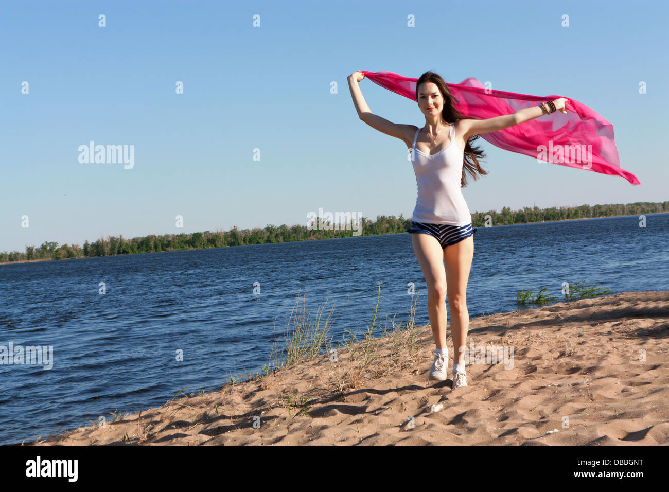 Woman running along Beach avec un chiffon Banque D'Images