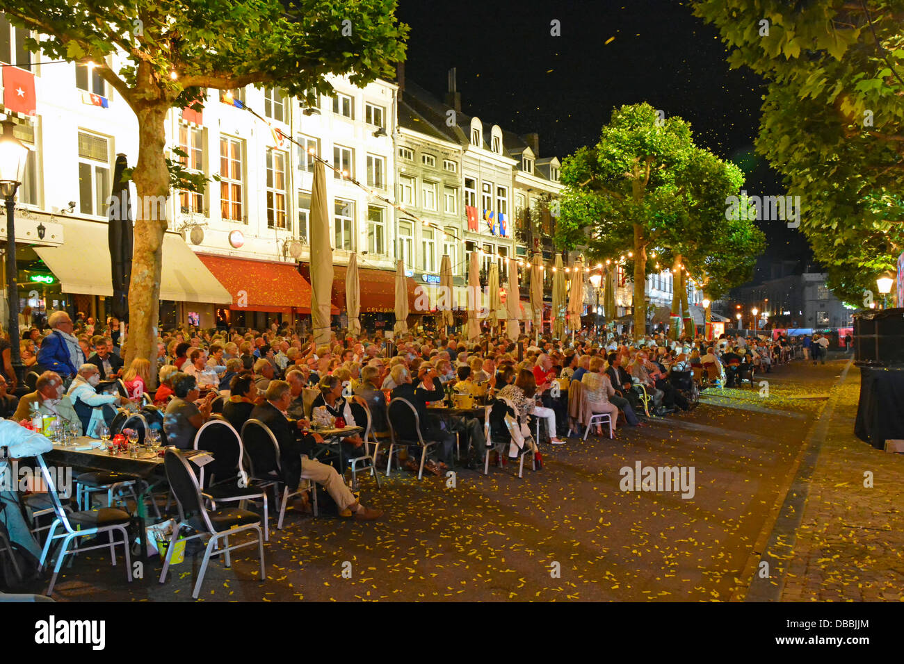 Le public de Maastricht les bars-restaurants assis dans la scène de rue de la place Vrijthof regardent l'orchestre André Rieu jouer le concert de musique du soir d'été eu Banque D'Images