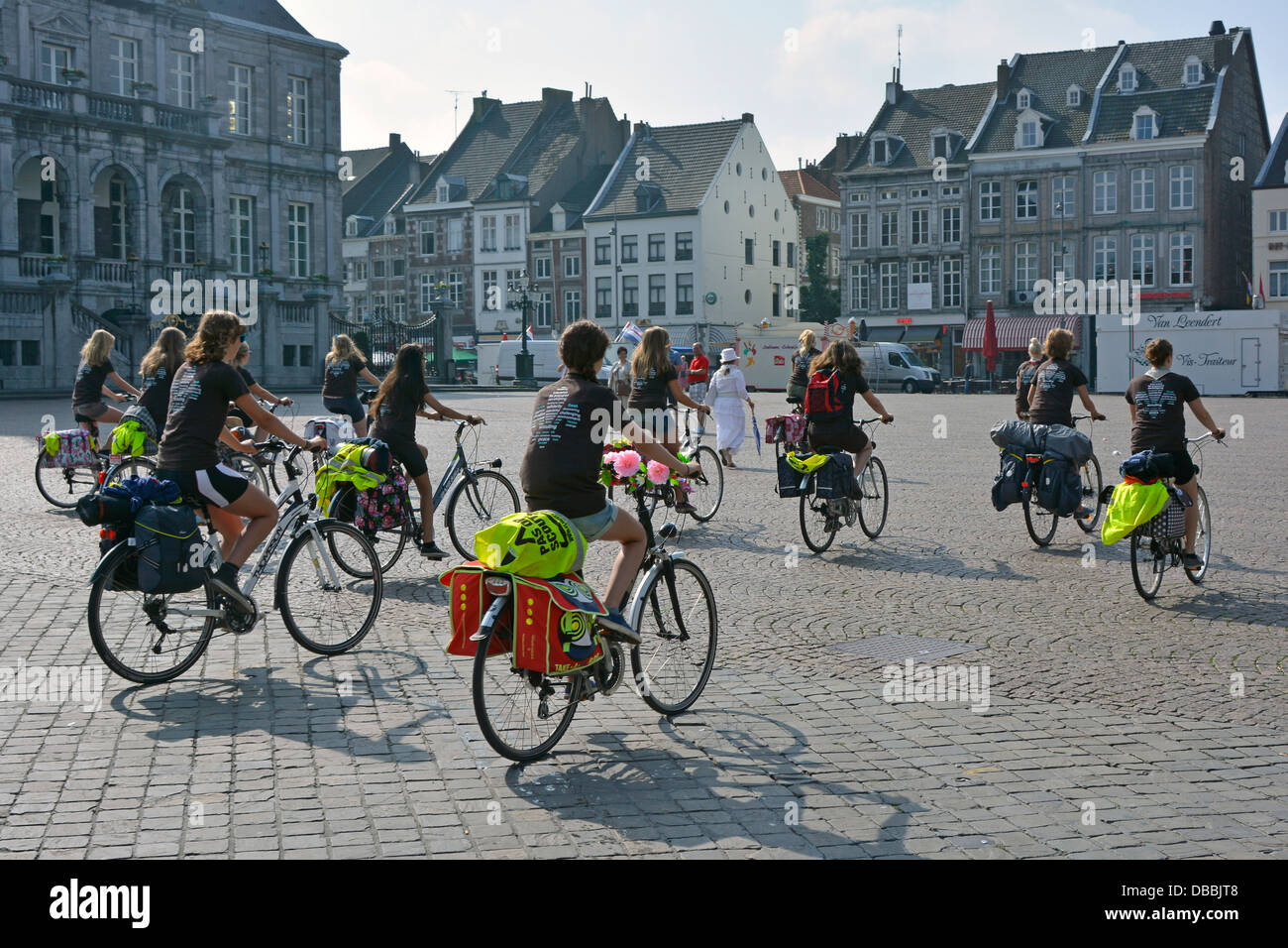Maastricht market Square Limburgh pays-Bas Europe groupe de cyclistes femmes toutes portant des emblèmes scout sur les uniformes de tee-shirt tôt le matin soleil eu Banque D'Images