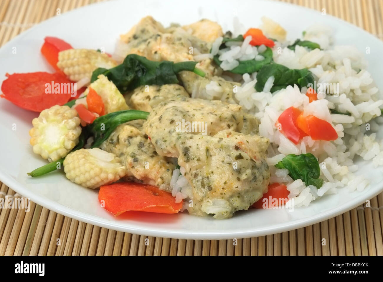 Poulet au curry vert thaï aux épinards, poivrons rouges, et des petits épis de maïs avec du riz Jasmin - faible profondeur de champ Banque D'Images