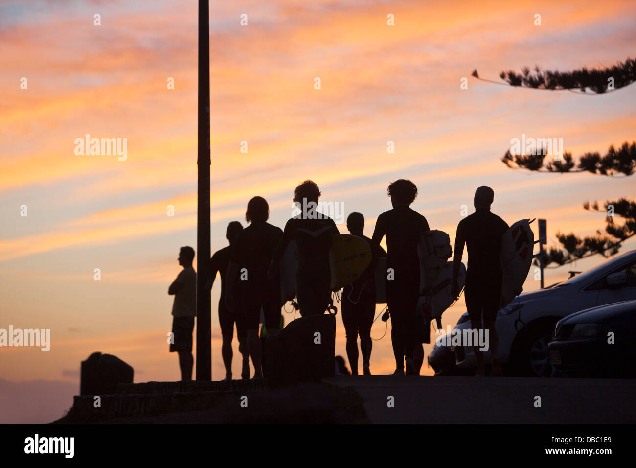 Les surfeurs à pied jusqu'à la plage à l'aube. Burleigh Heads, Gold Coast, Queensland, Australie Banque D'Images