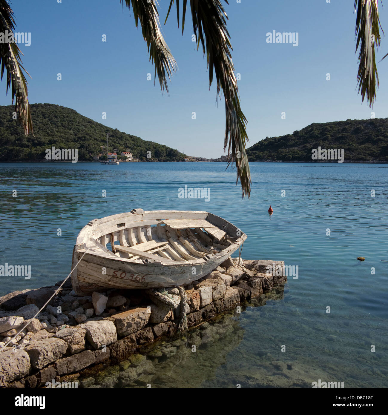 Vieux bateau aviron blanc par une baie sur l'île de Sipan, côte dalmate, à proximité de Dubrovnik Croatie Banque D'Images