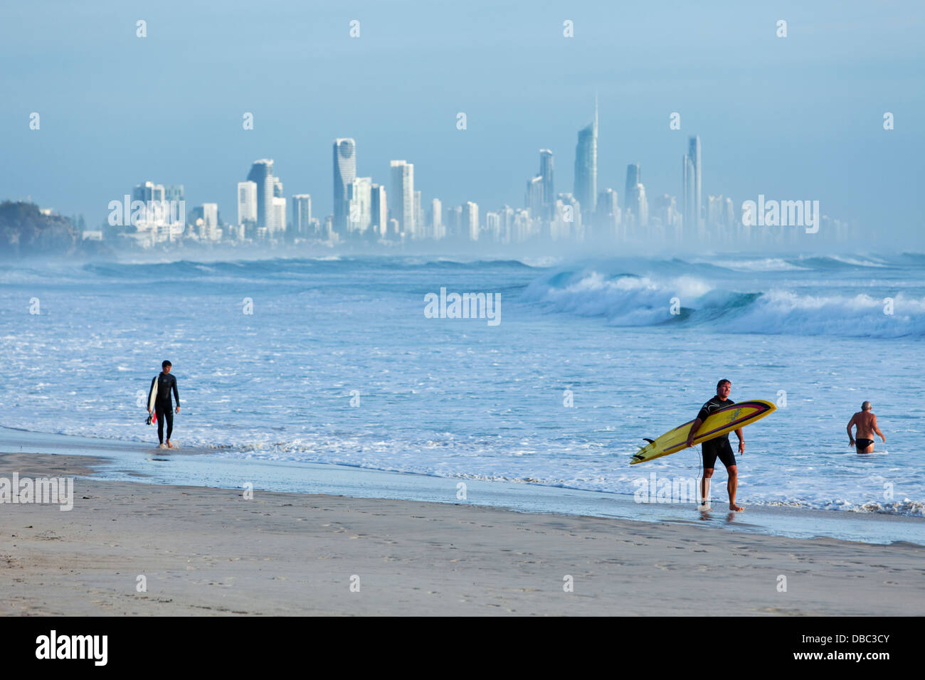 Les surfeurs sur la plage au Burleigh Heads à Surfers Paradise, en arrière-plan. Burley Heads, Gold Coast, Queensland, Australie Banque D'Images
