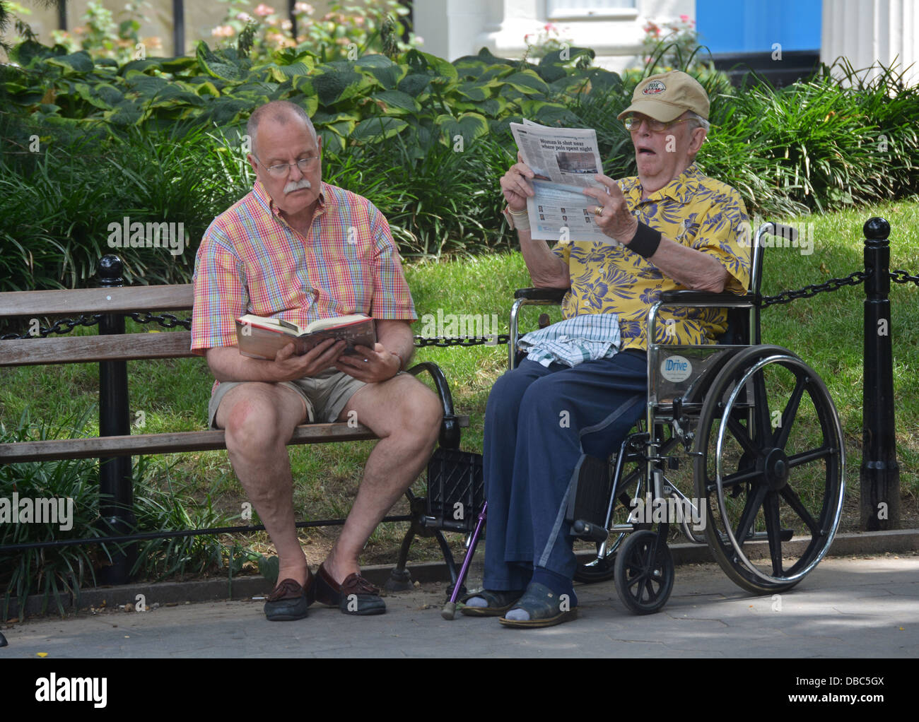 Deux hommes plus âgés lecture à Washington Square Park à Greenwich Village, New York City Banque D'Images