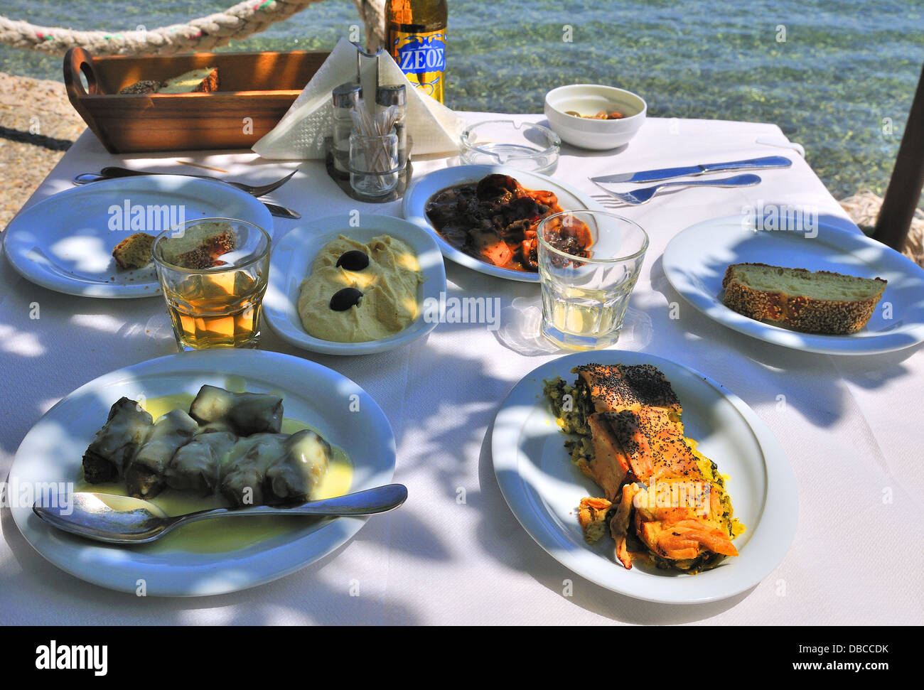 Taverne au bord de l'eau -la nourriture grecque de feuilles de vigne en sauce au citron, calamars à la sauce tomate, les olives et l'humus de Port,Péloponnèse Grèce,Epidavros Banque D'Images