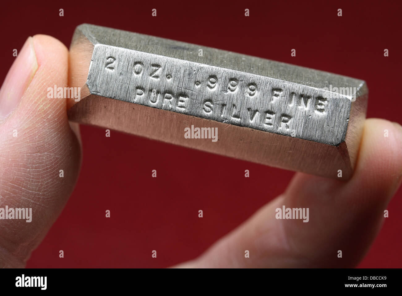 2 Onces de lingots d'argent Bar tenu entre les doigts Banque D'Images