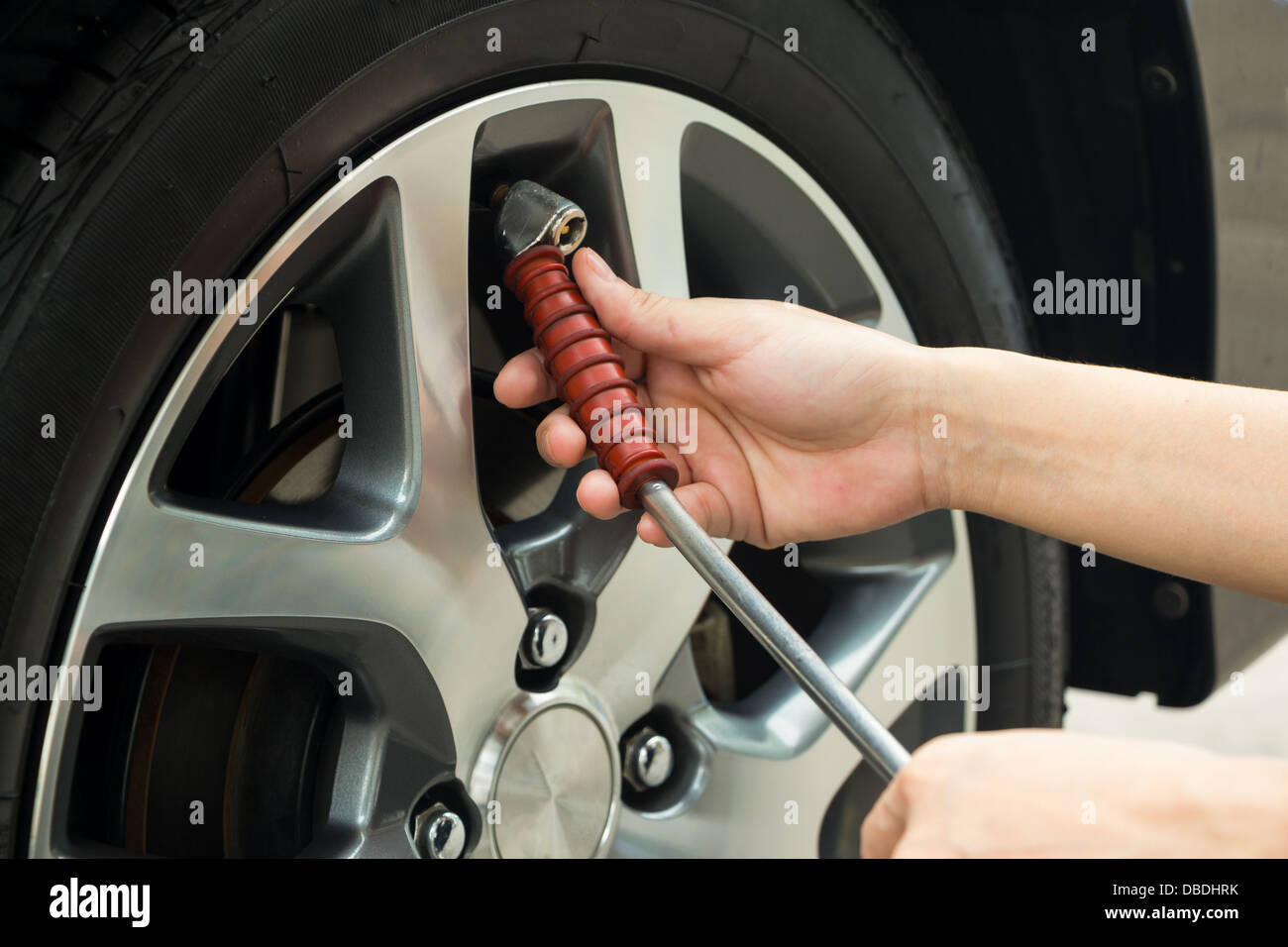 Remplir la main de l'air dans un pneu de voiture. Banque D'Images