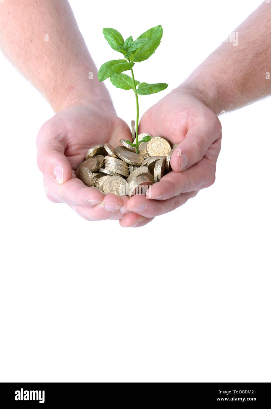 Mains tenant un tas de pièces de monnaie avec une plante poussant hors d'eux, concept de l'expansion monétaire, isolé sur fond blanc Banque D'Images