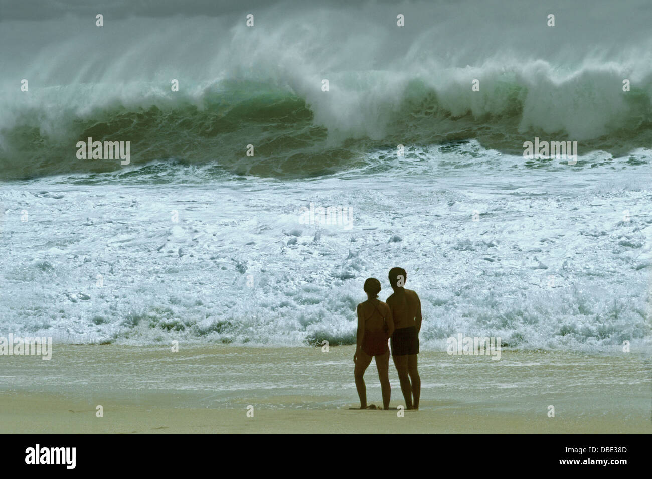 Une tempête montres couple jeté surfez comme une tempête tropicale d'approches. Banque D'Images