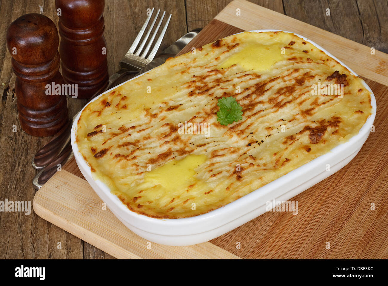 Poisson traditionnel fait maison tarte dans une casserole avec la purée de pommes de terre croustillantes sur une table de cuisine rustique Banque D'Images