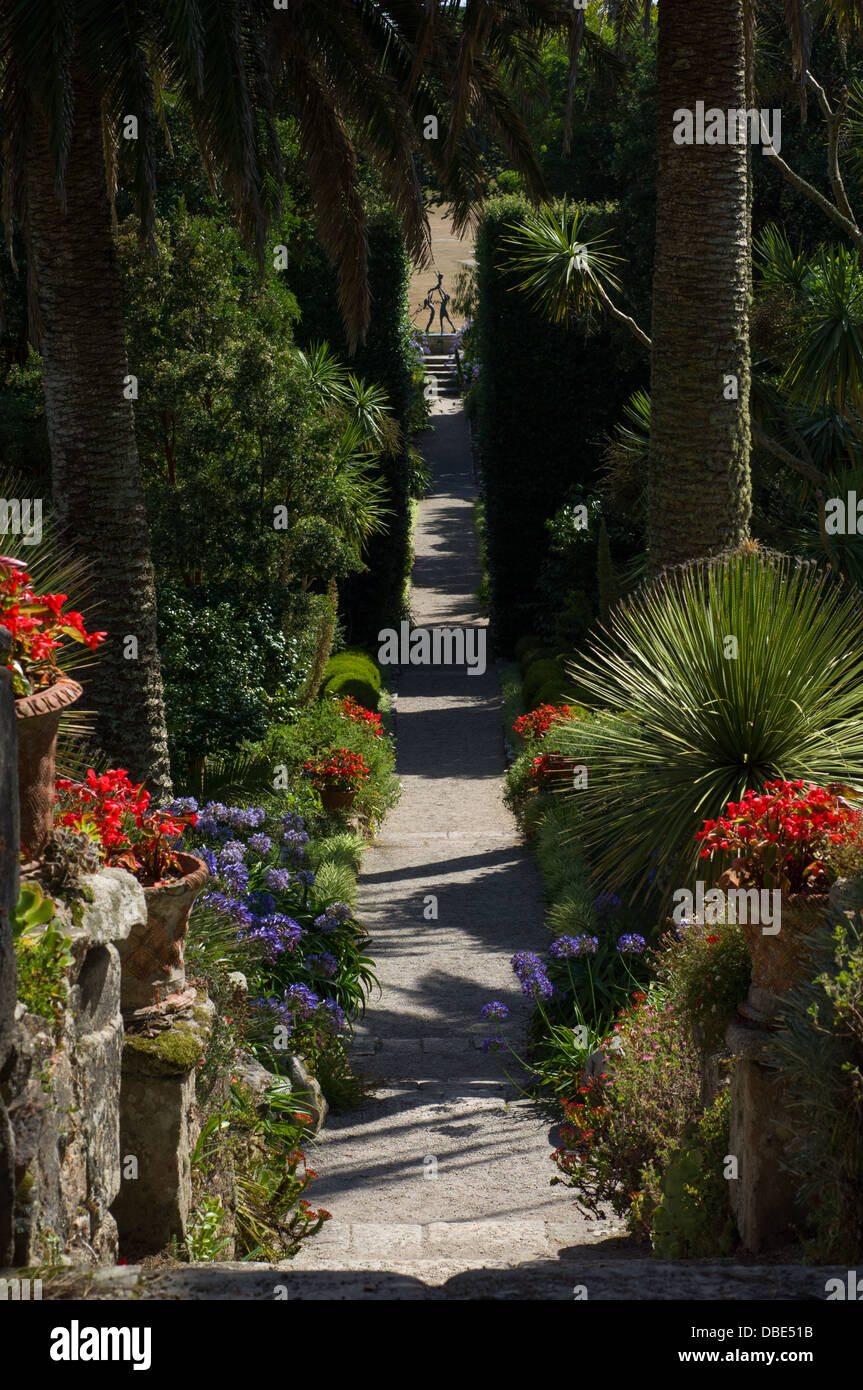 En regardant une avenue de plantes vers une statue en bronze appelé enfants Tresco par David Wynne , Jardin de l'abbaye de Tresco, Tresco, Îles Scilly, Angleterre Banque D'Images