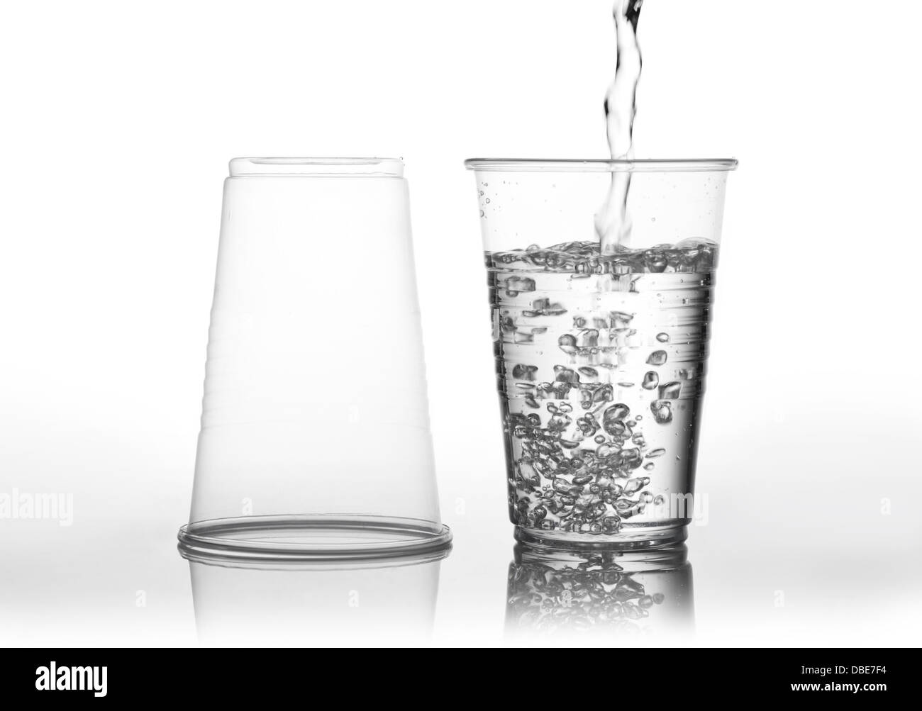 Verser de l'eau dans une tasse d'usure transparente Banque D'Images