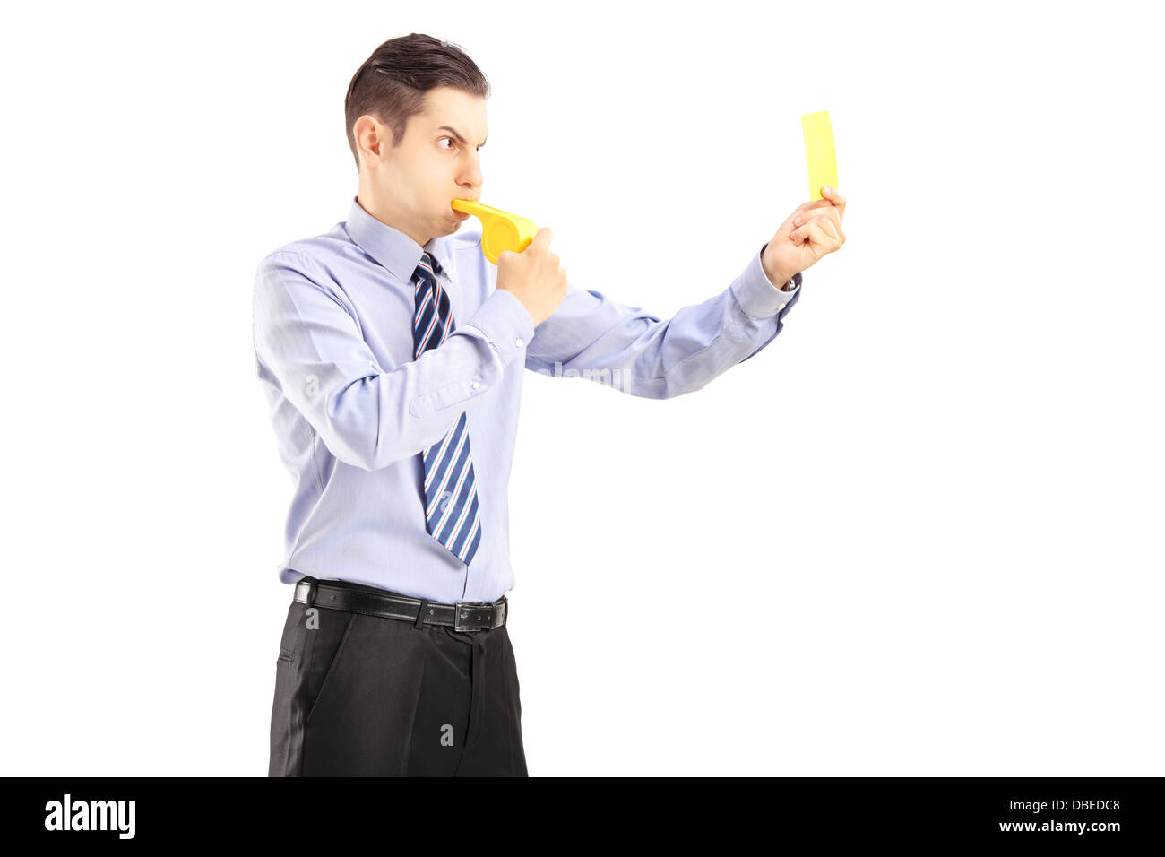 Jeune homme qui souffle dans un sifflet et montrant une carte jaune Banque D'Images