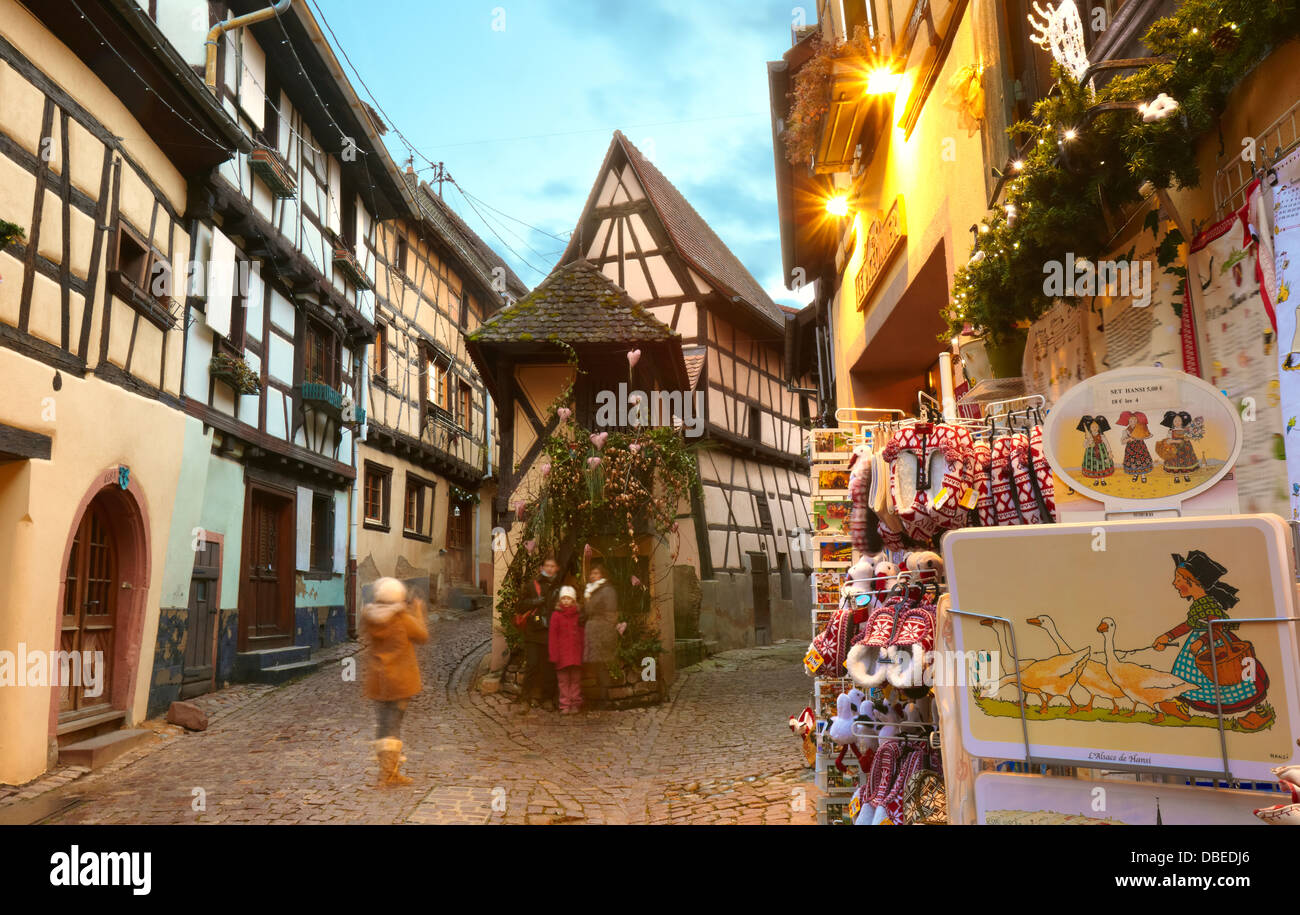 Fille de prendre une photo à l'ossature de bois typique des maisons. Eguisheim. Route des vins. Haut-Rhin. L'Alsace. France Banque D'Images