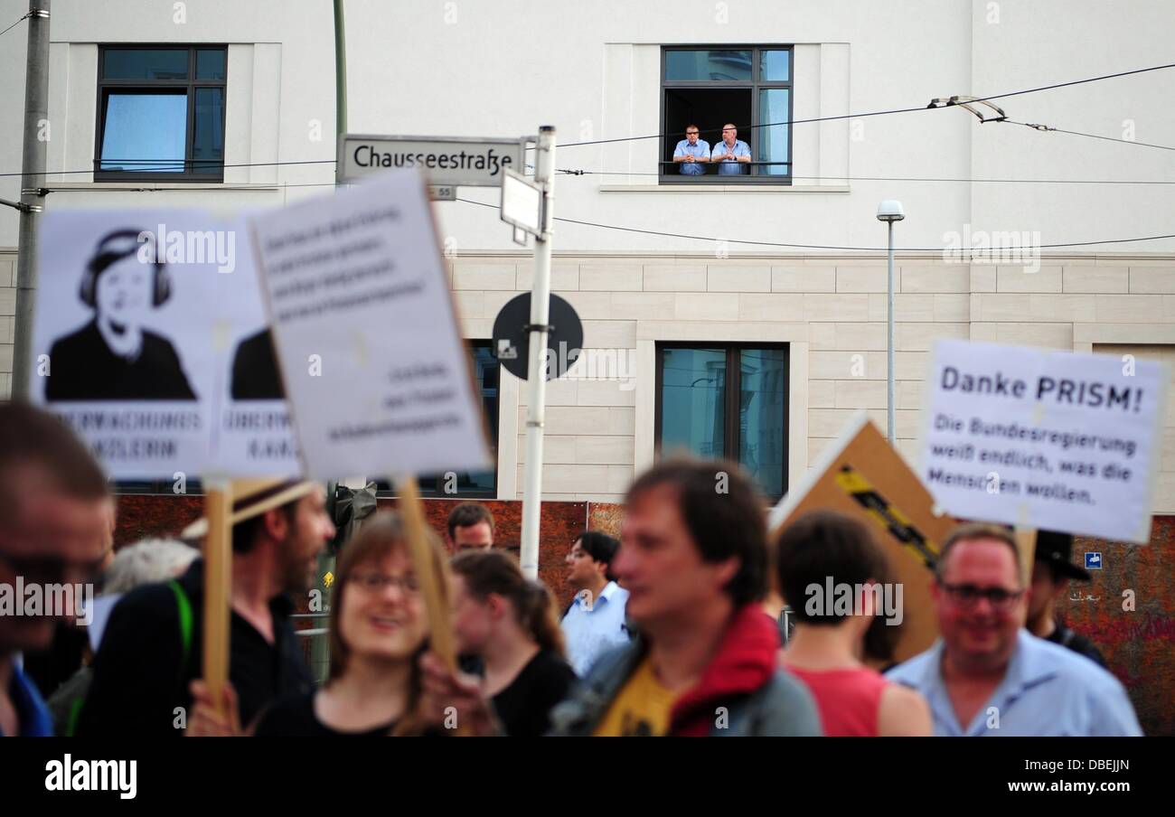 Deux hommes regarder une marche de protestation contre la surveillance en face du nouveau bâtiment de la d'une fenêtre de l'Service fédéral de renseignements (BND) à partir d'une fenêtre de même bâtiment à Berlin, Allemagne, 29 juillet 2013. Les militants de l'Internet La société 'Digital' avait appelé à la manifestation. Photo : Daniel Reinhardt Banque D'Images