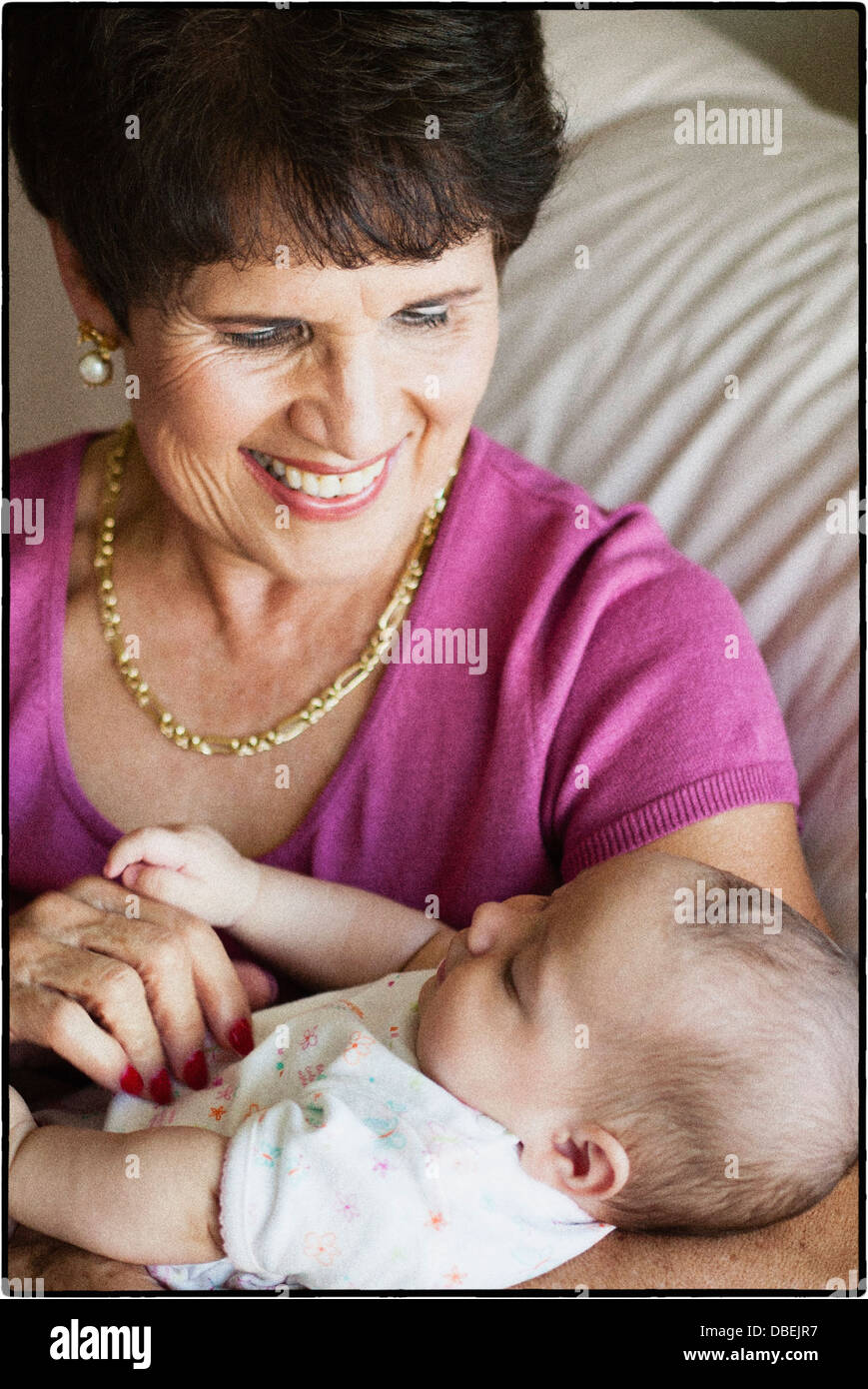 Older Hispanic woman holding baby grand - Image de stock capturée avec un smartphone