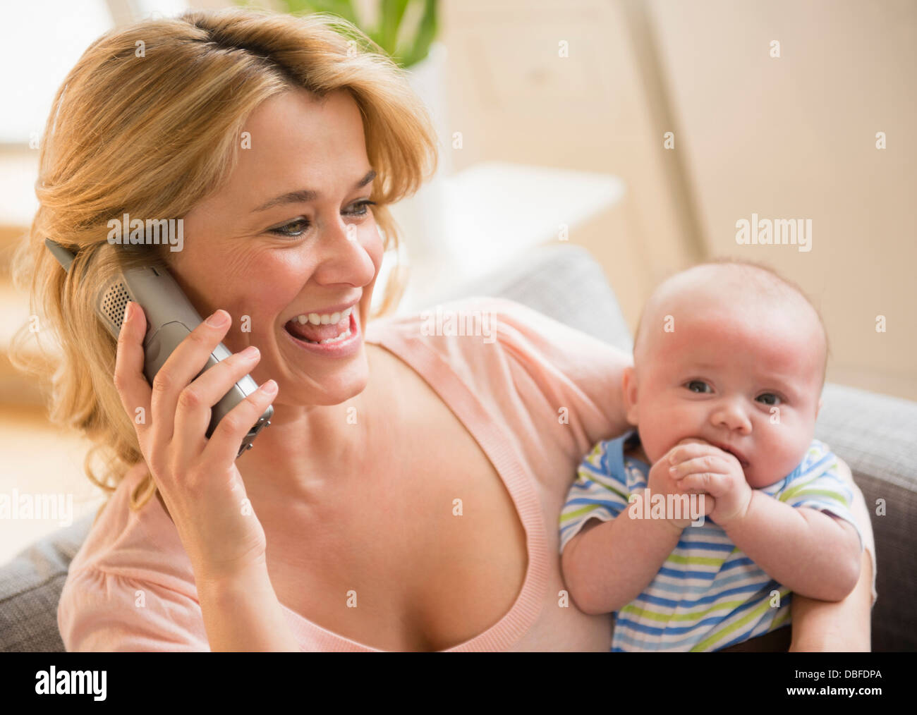 Caucasian mother with baby talking on telephone Banque D'Images