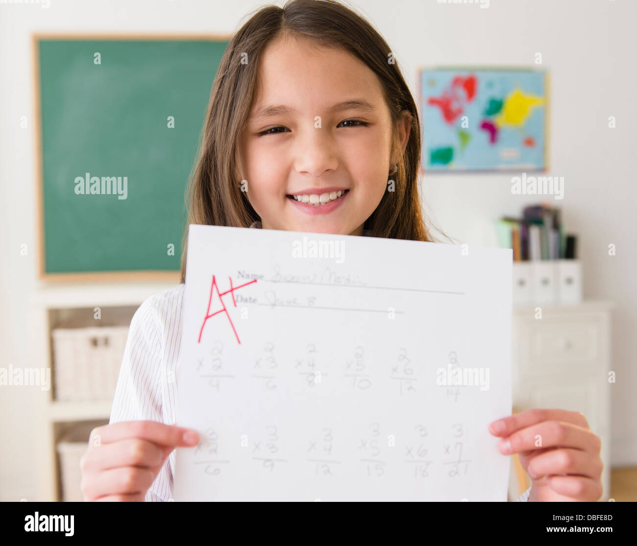 Mixed Race girl holding papier avec un grade + Banque D'Images