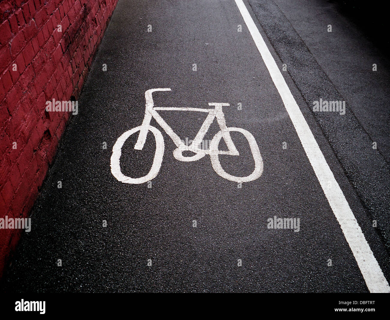 Cycle path symbole sur un trottoir de la chaussée. Une solide ligne sépare la piste cyclable de la voie piétonne. Banque D'Images