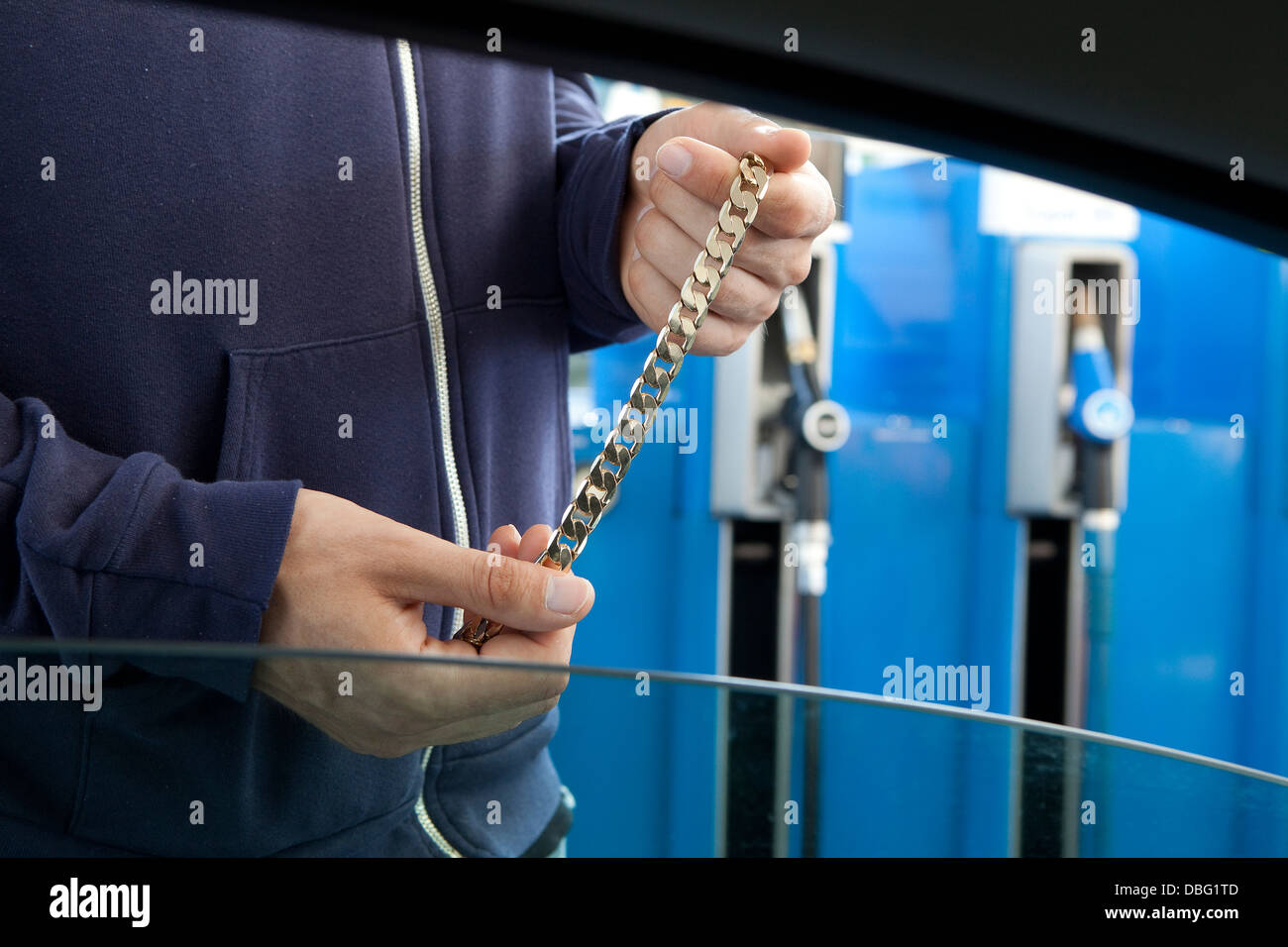 Un homme propose des bijoux volés à une station essence Banque D'Images
